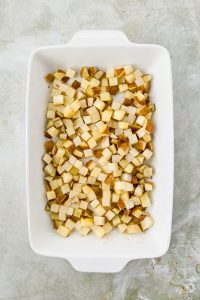 cubed russet potatoes in white casserole dish.