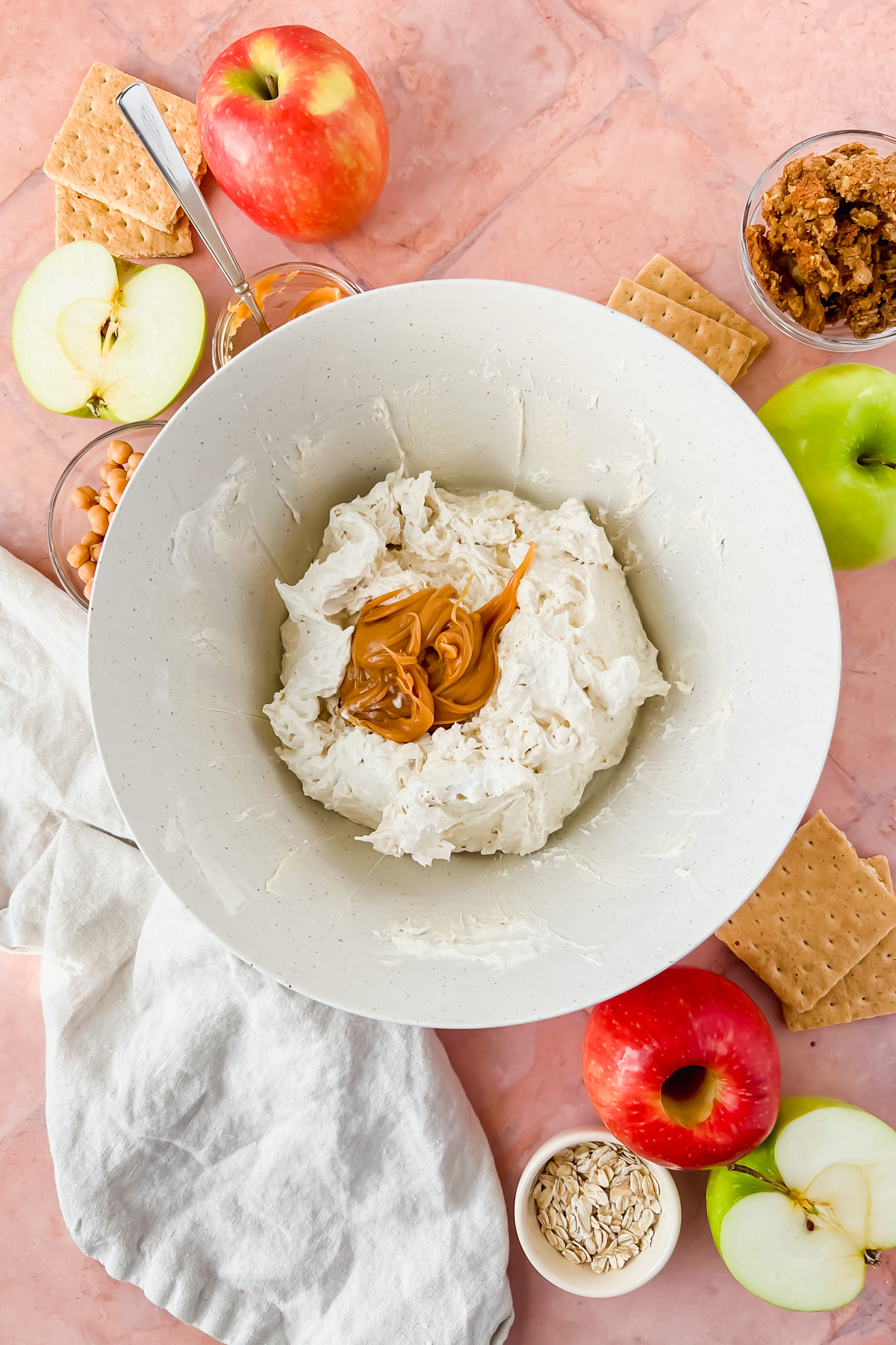 cream cheese caramel apple dip base with caramel on top before mixing in white mixing bowl.
