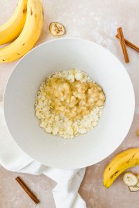 butter, sugar, and mashed banana in white mixing bowl.