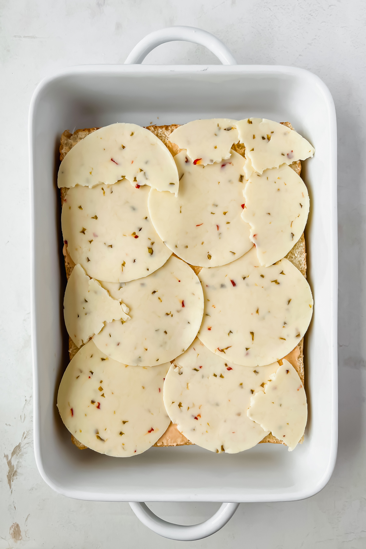 pepper jack cheese layed on rotisserie chicken hawaiian sliders.