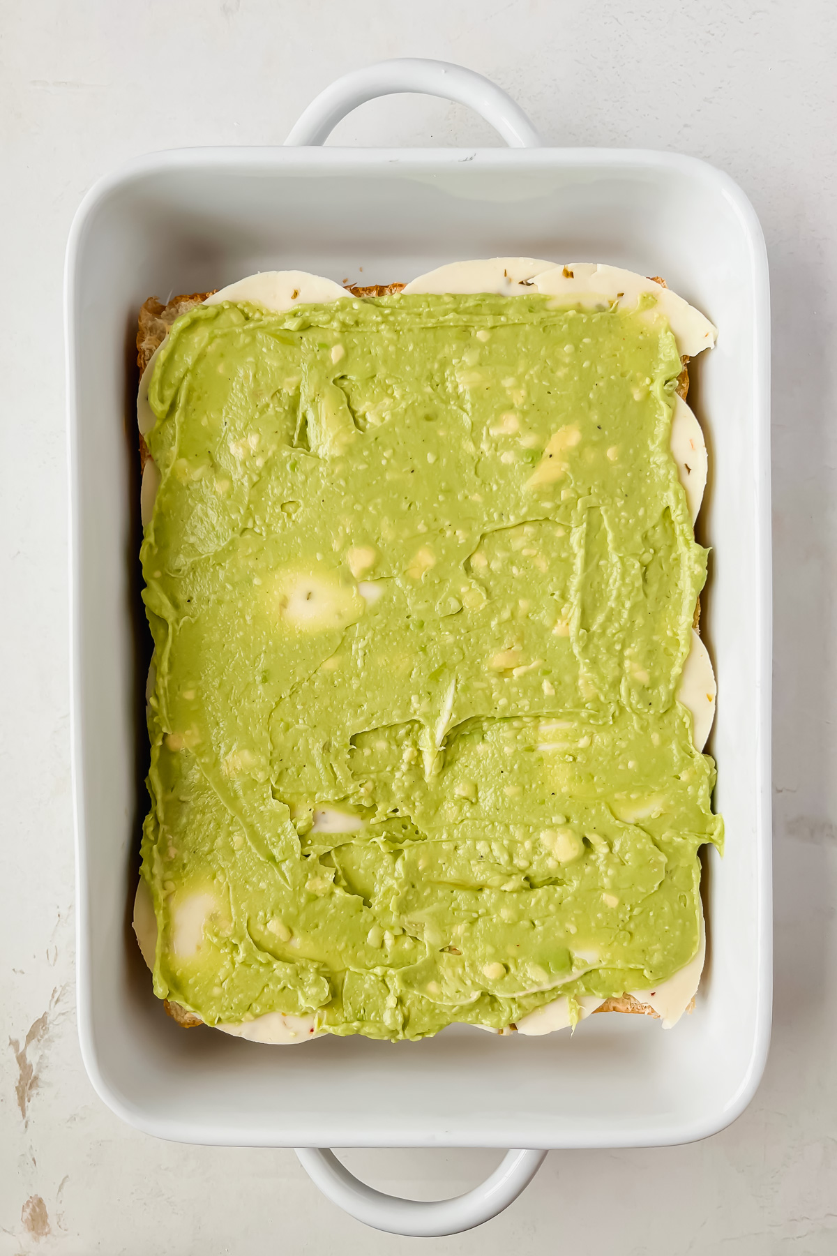 cheese and guacamole spread on hawaiian slider buns.