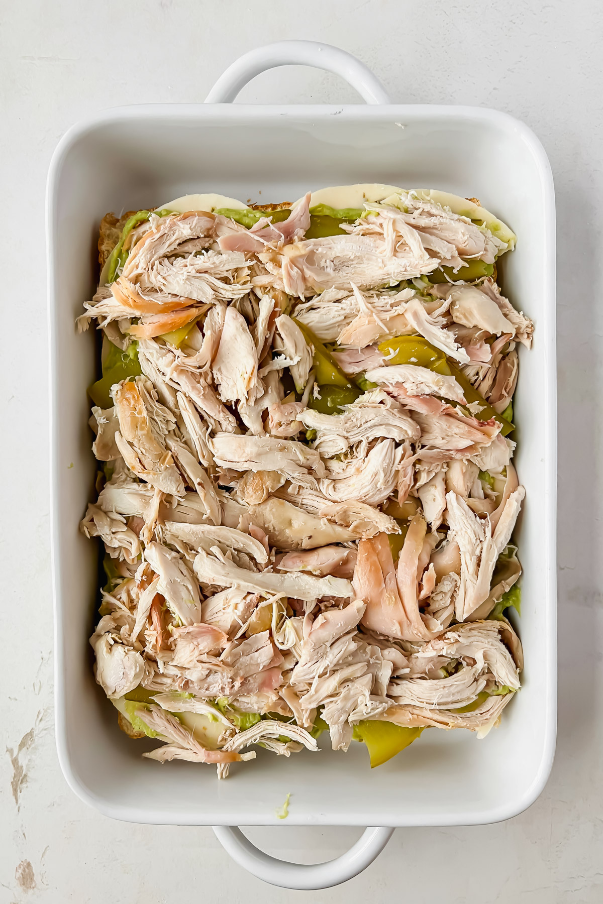 open faced rotisserie chicken hawaiian sliders in white baking dish.