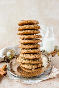 10 snickerdoodle oatmeal cookies stacked on top of each other on silver tray.