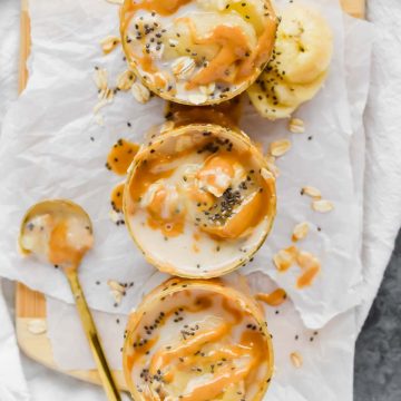 three glasses filled with peanut butter banana overnight oats dripping with peanut butter.
