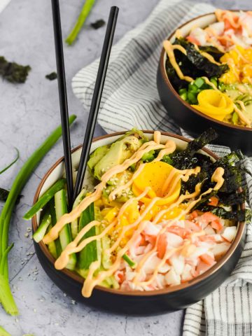 two California roll poke bowls drizzled with spicy mayo.