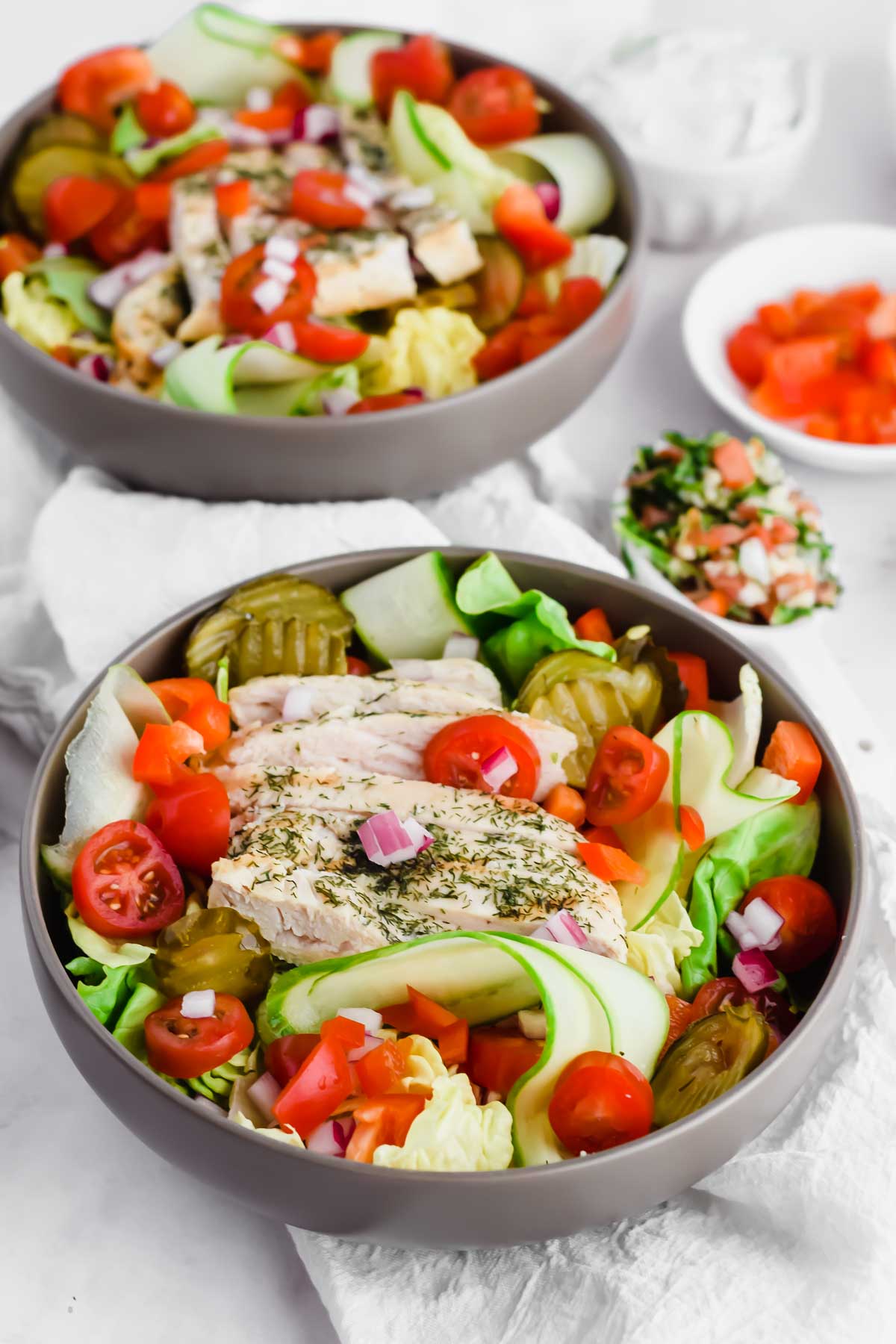 loaded Mediterranean salad with chicken, pita, tomatoes, red onions, and pickles.