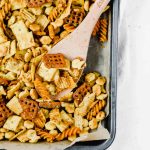 platter of ranch snack mix with wooden spoon lifting up the mix.