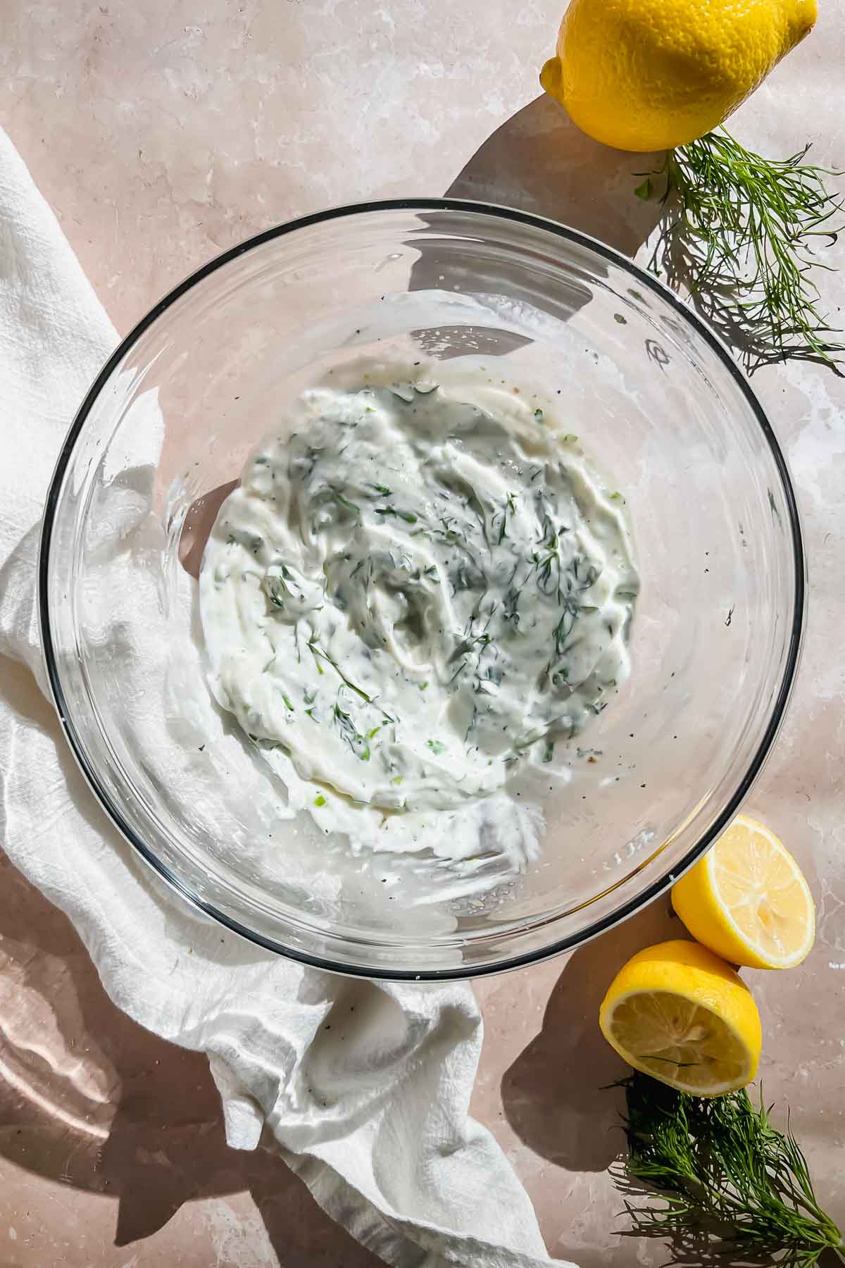 healthy lemon dill potato salad dressing mixed in glass mixing bowl.