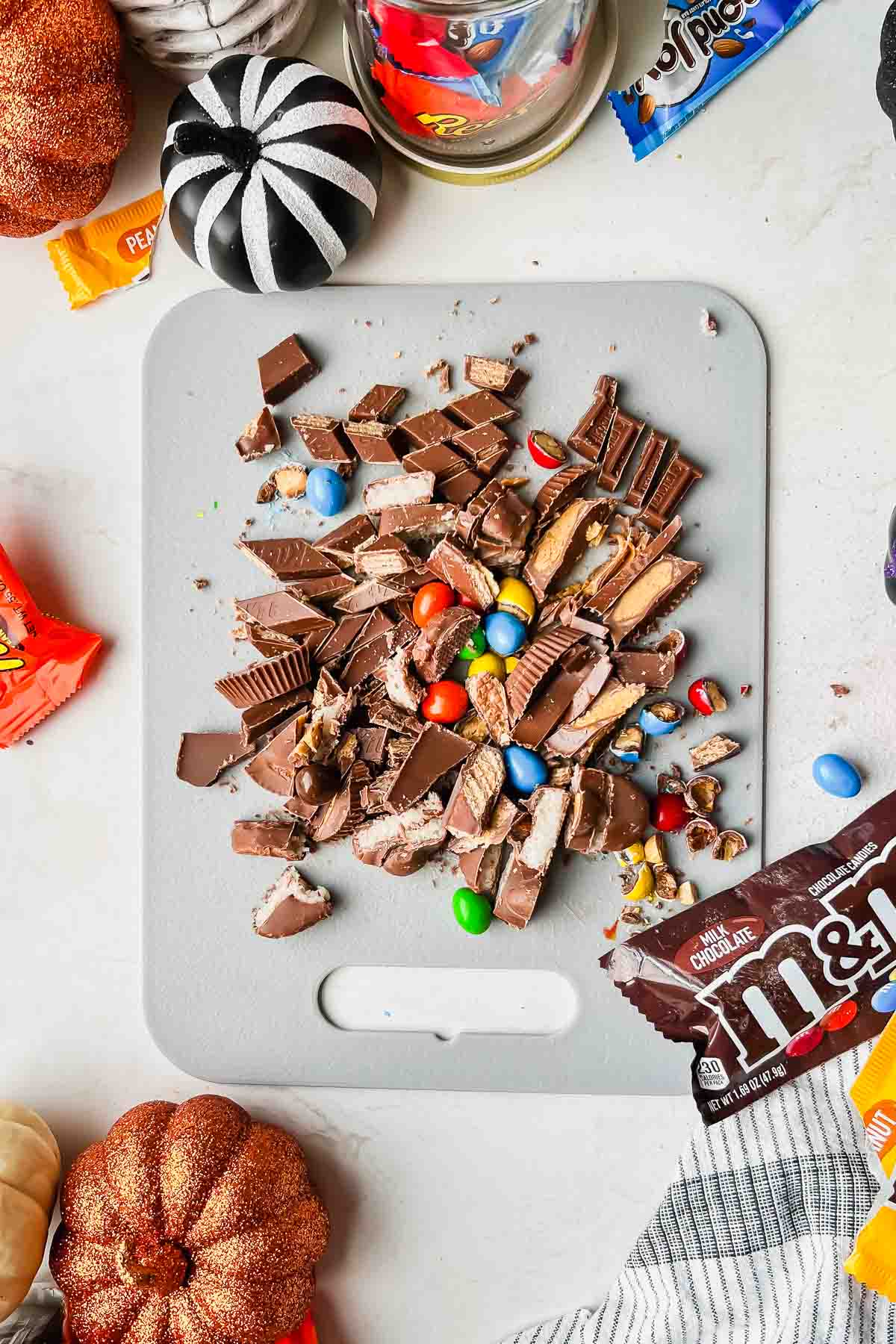 chopped up leftover halloween candy on gray cutting board.