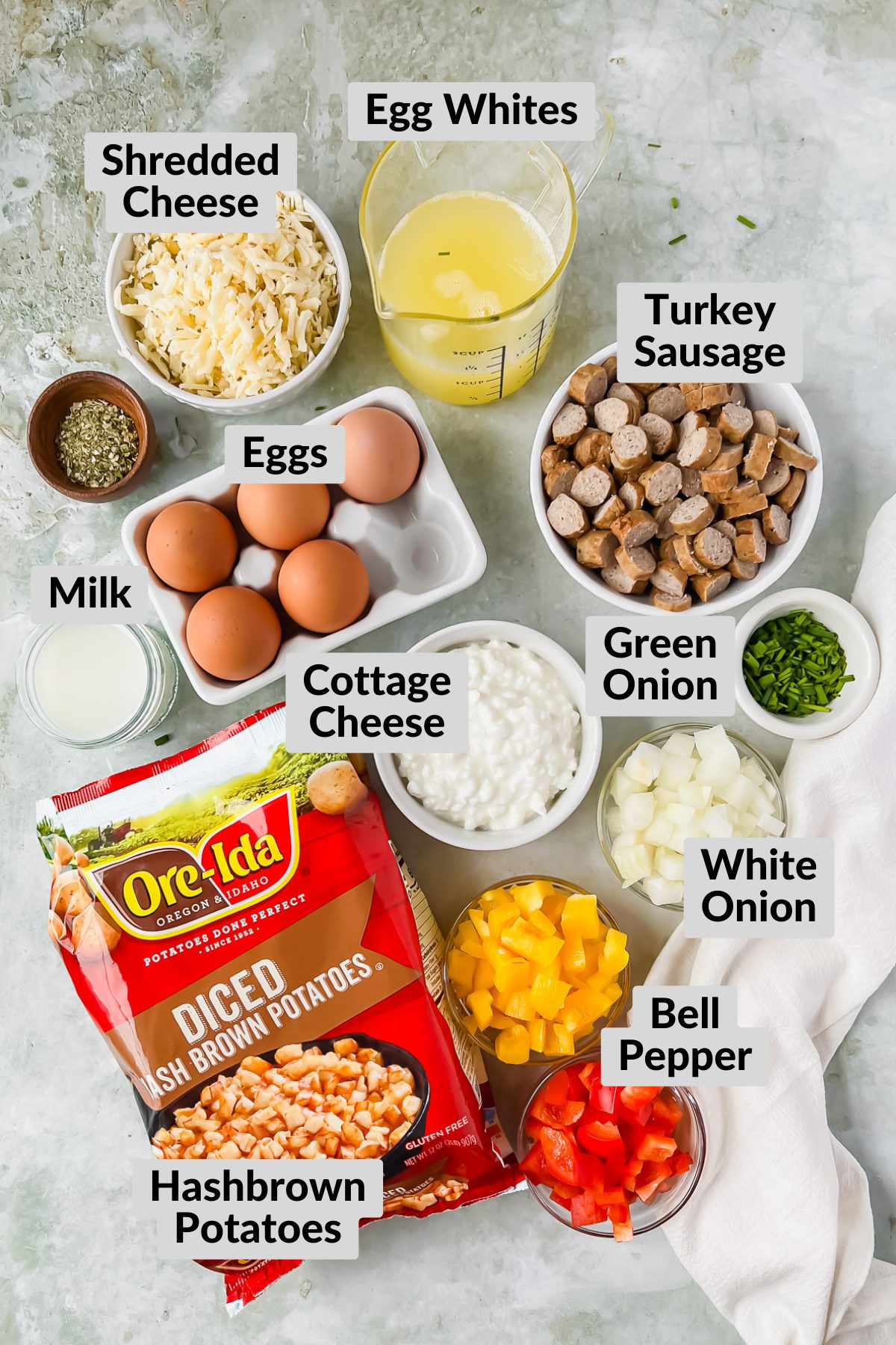 ingredients for loaded hashbrown casserole in individual bowls on gray background.