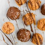 Scooping peanut butter on a tray of chocolate peanut butter truffles.