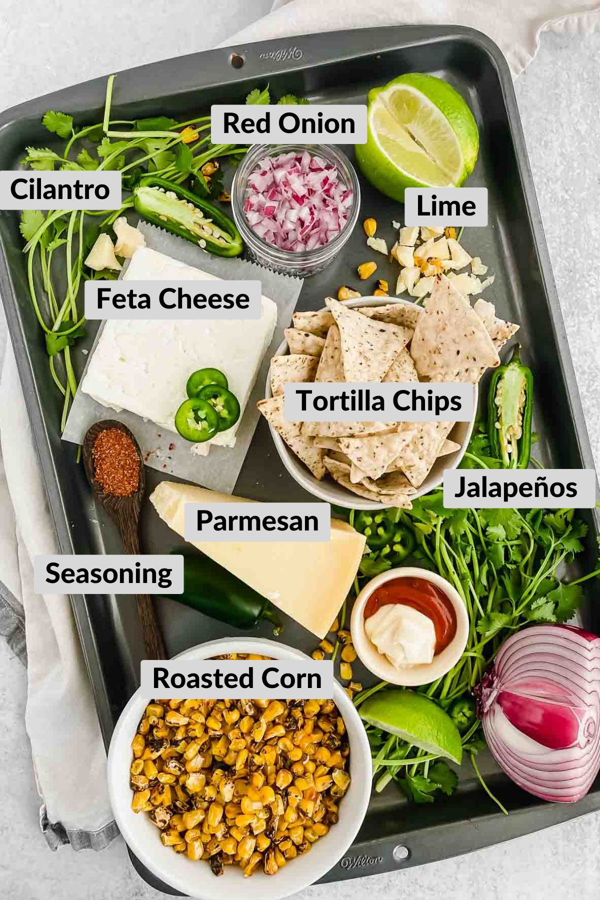 ingredients needed for spicy corn feta dip on metal sheet pan.