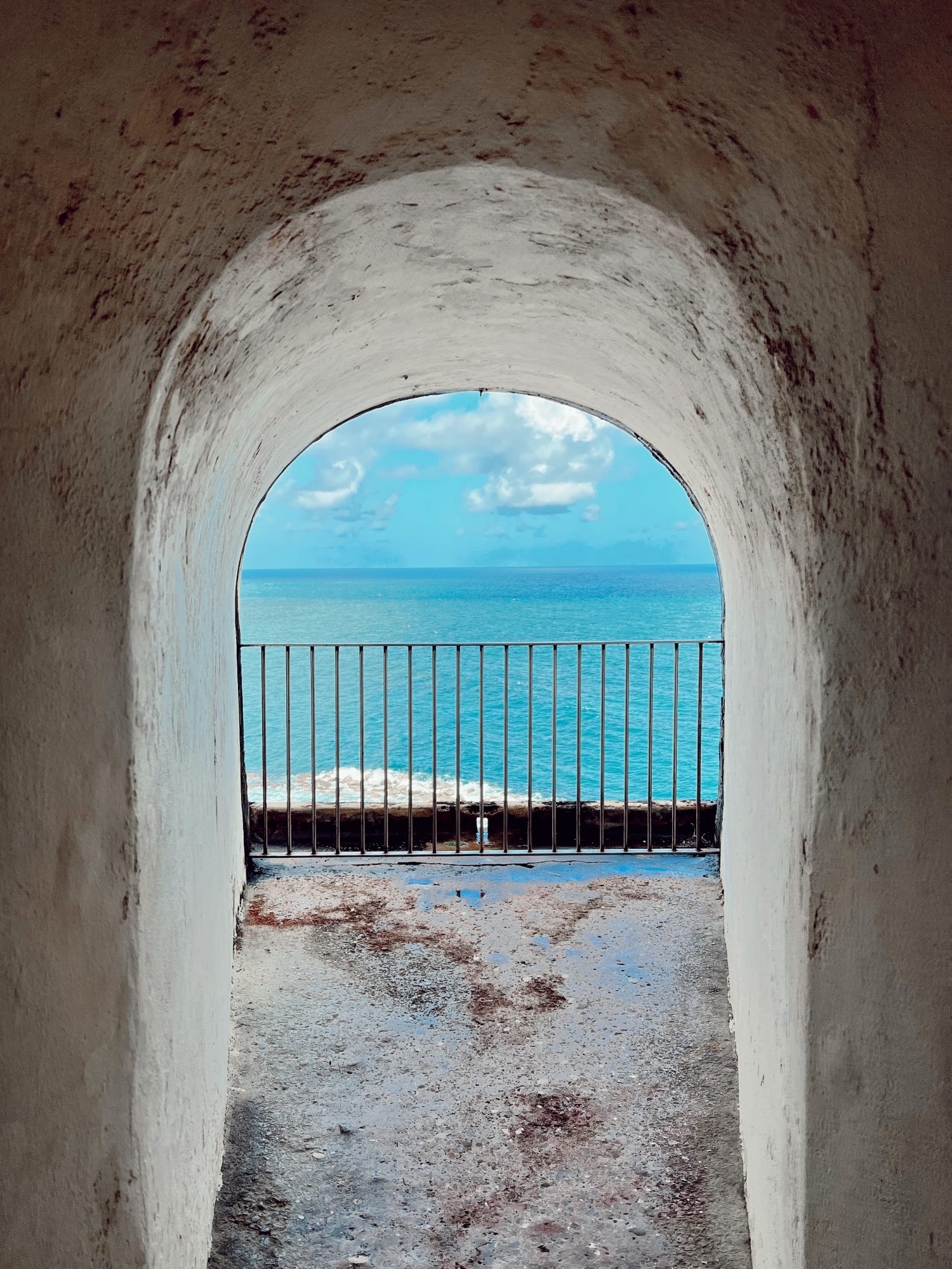 alcove of an old building looking out to the Caribbean sea's blue water. 