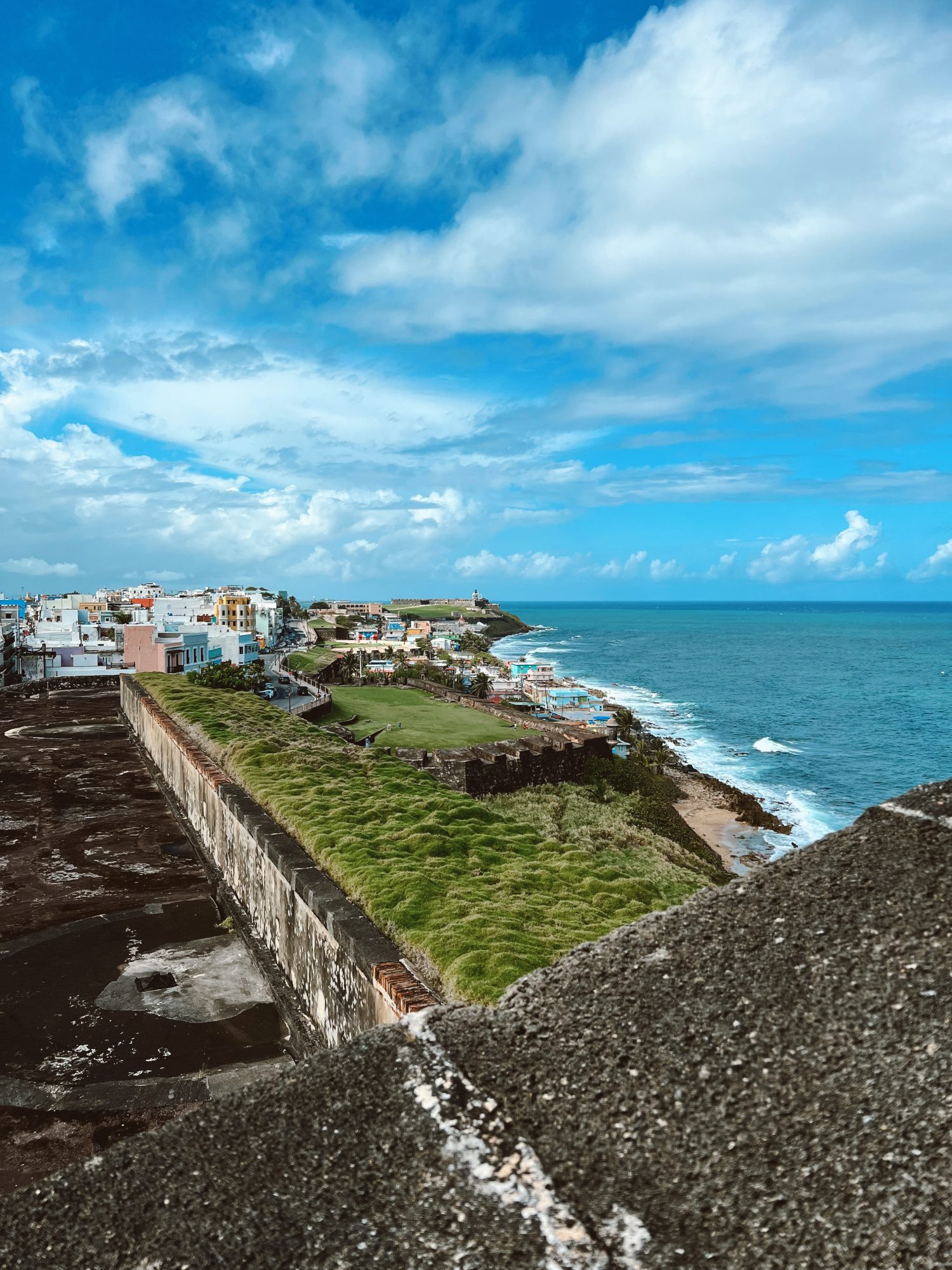 view from the top of a castle overlooking San Juan's coastline and cityscape.