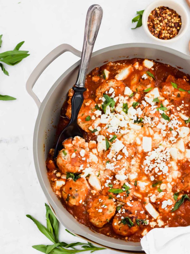 Turkey Feta Meatballs in a gray skillet with a serving spoon.