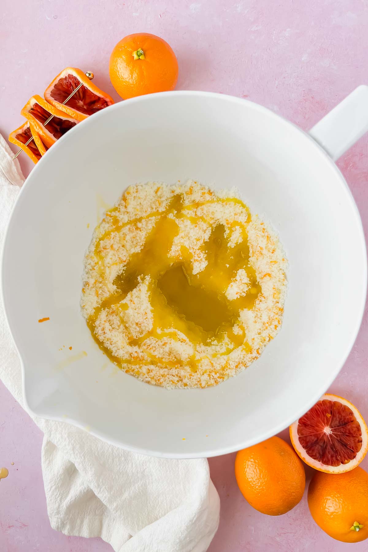 butter, olive oil and blood orange zest mixed in white mixing bowl.