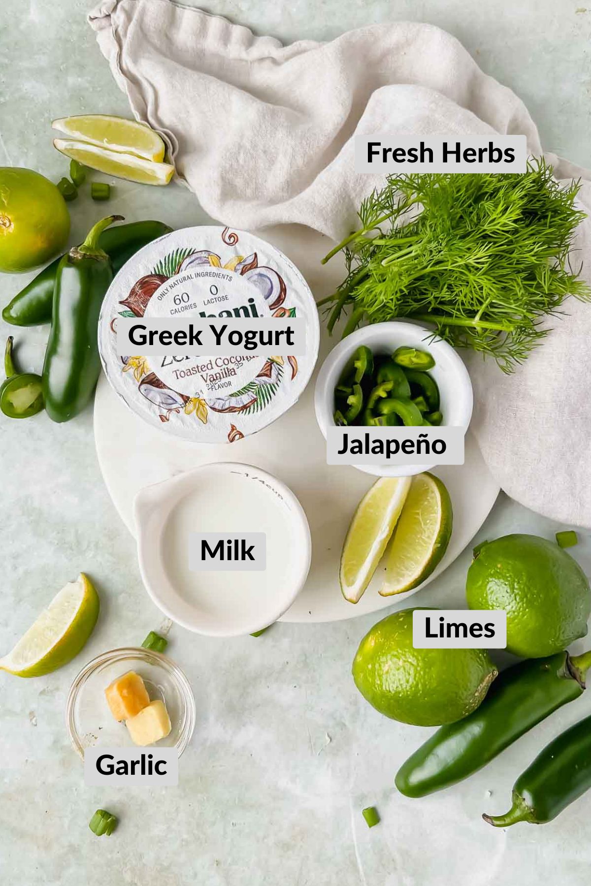 ingredients for creamy jalapeno sauce in individual bowls on green background. 