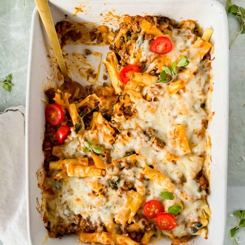 healthy baked ziti in white casserole dish with one serving removed from pan.