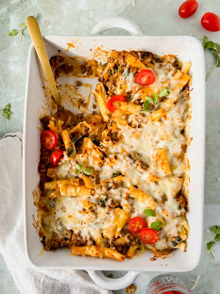 healthy baked ziti in white casserole dish with one serving removed from pan.