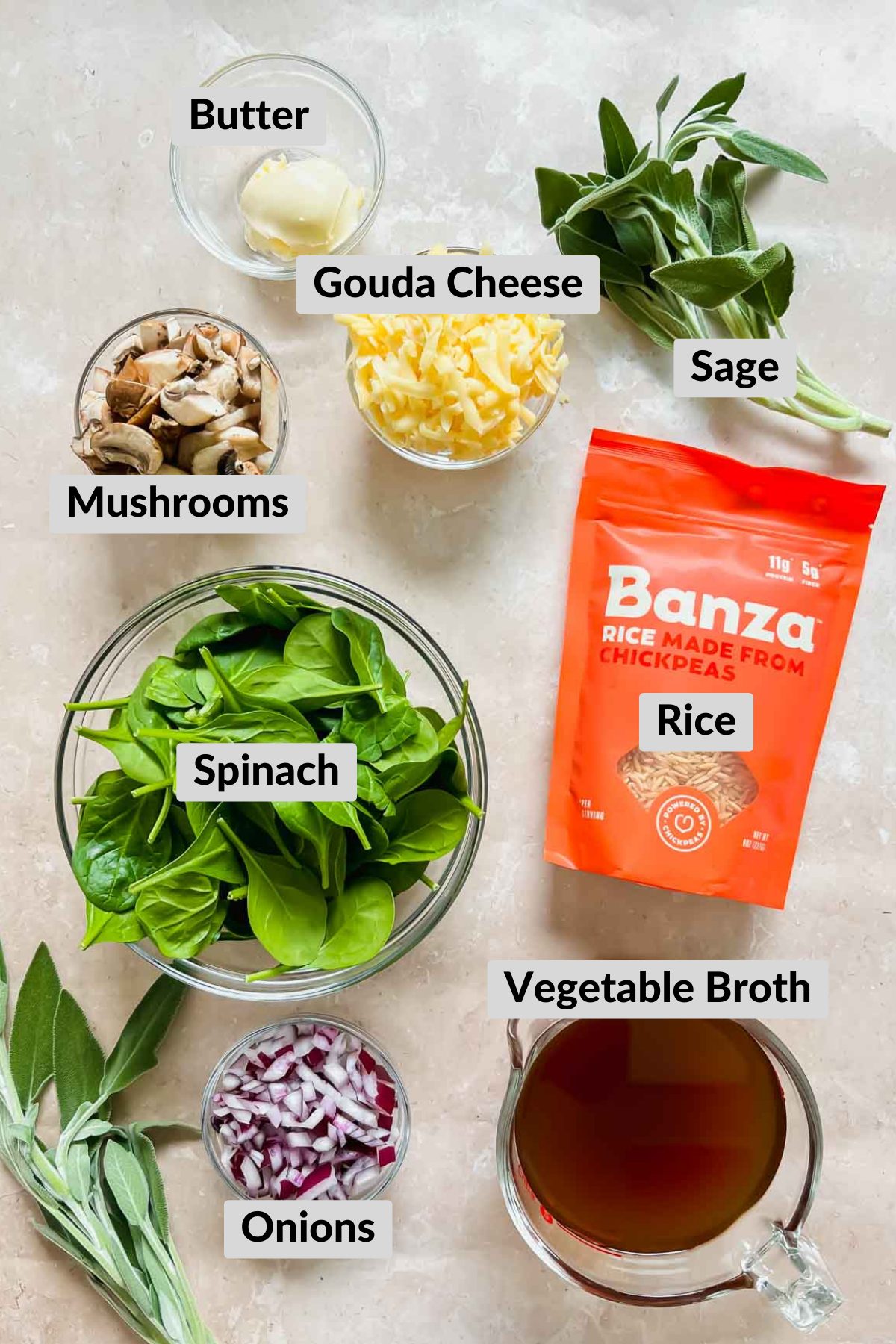 Mushroom Rice Pilaf ingredients including a bag of Banza rice, sage, mushrooms, butter, white onion, and spinach.