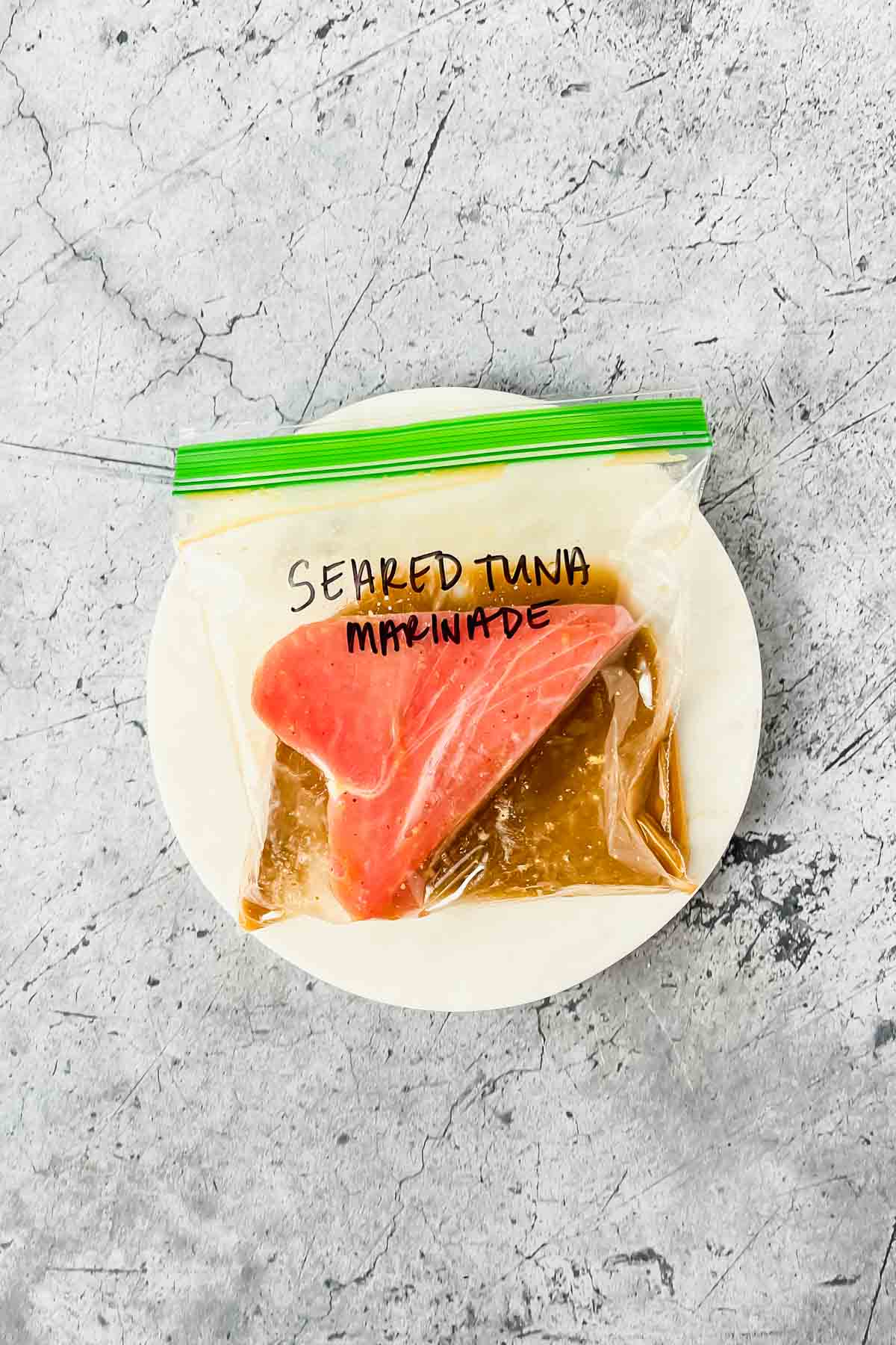 raw ahi tuna marinating in sauce in ziplock bag.