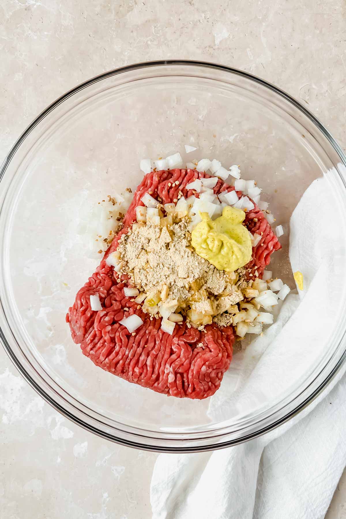 raw ingredients for california burger unmixed in glass mixing bowl.