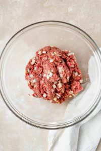 raw ingredients for california burger mixed in glass mixing bowl.