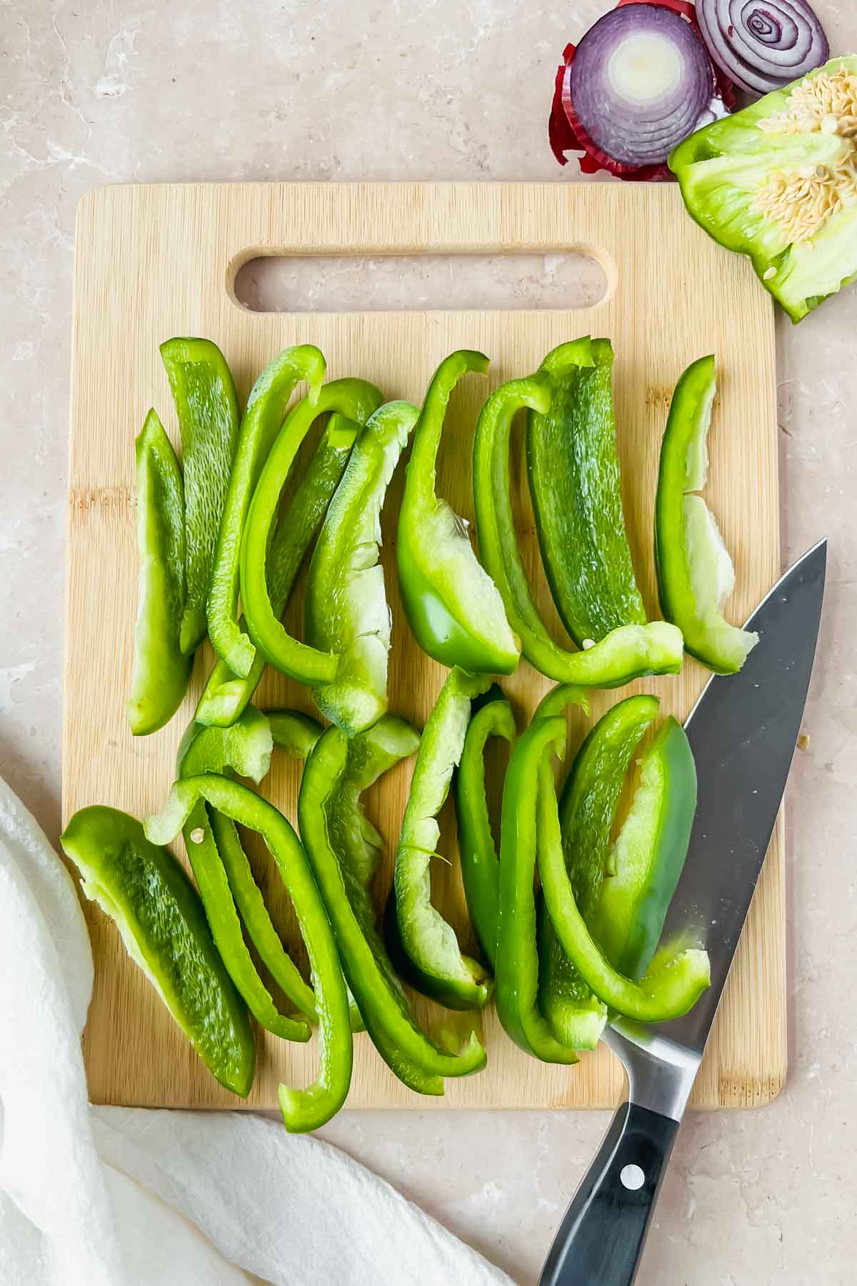 sliced green bell peppers on wood cutting board.
