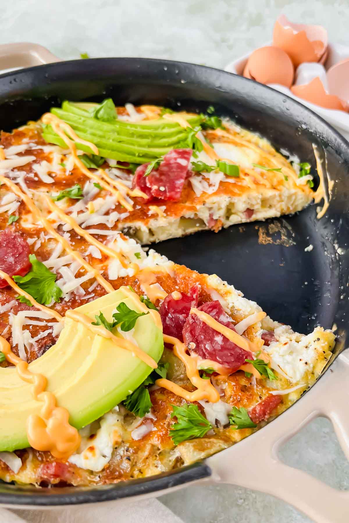 close up of salami and egg frittata with a slice cut out. 