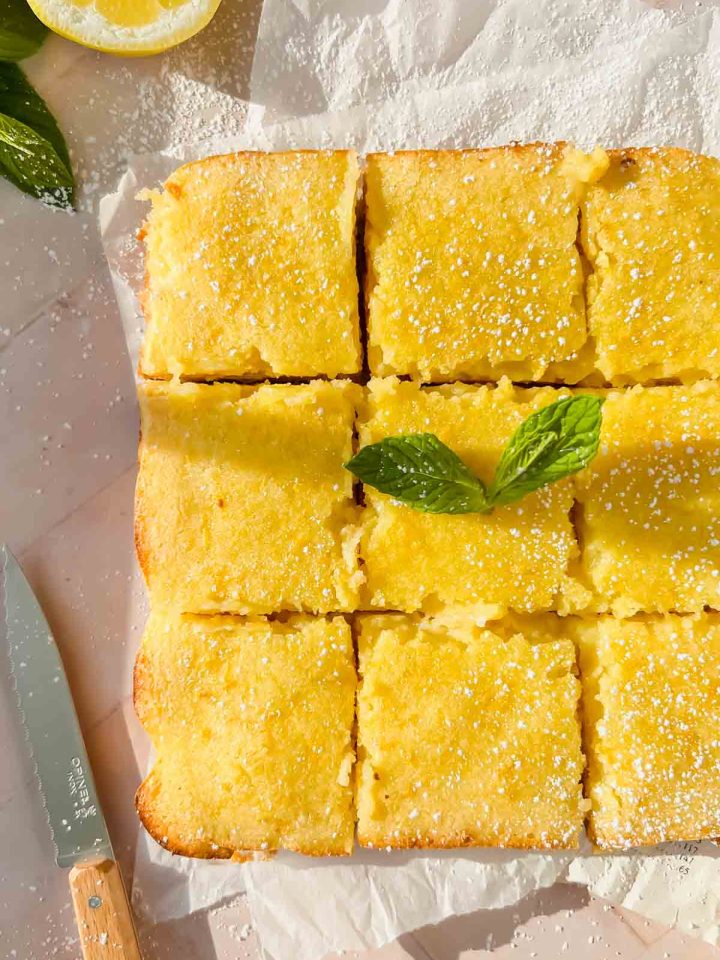 dairy free lemon bars sliced into nine squares dusted with powdered sugar.