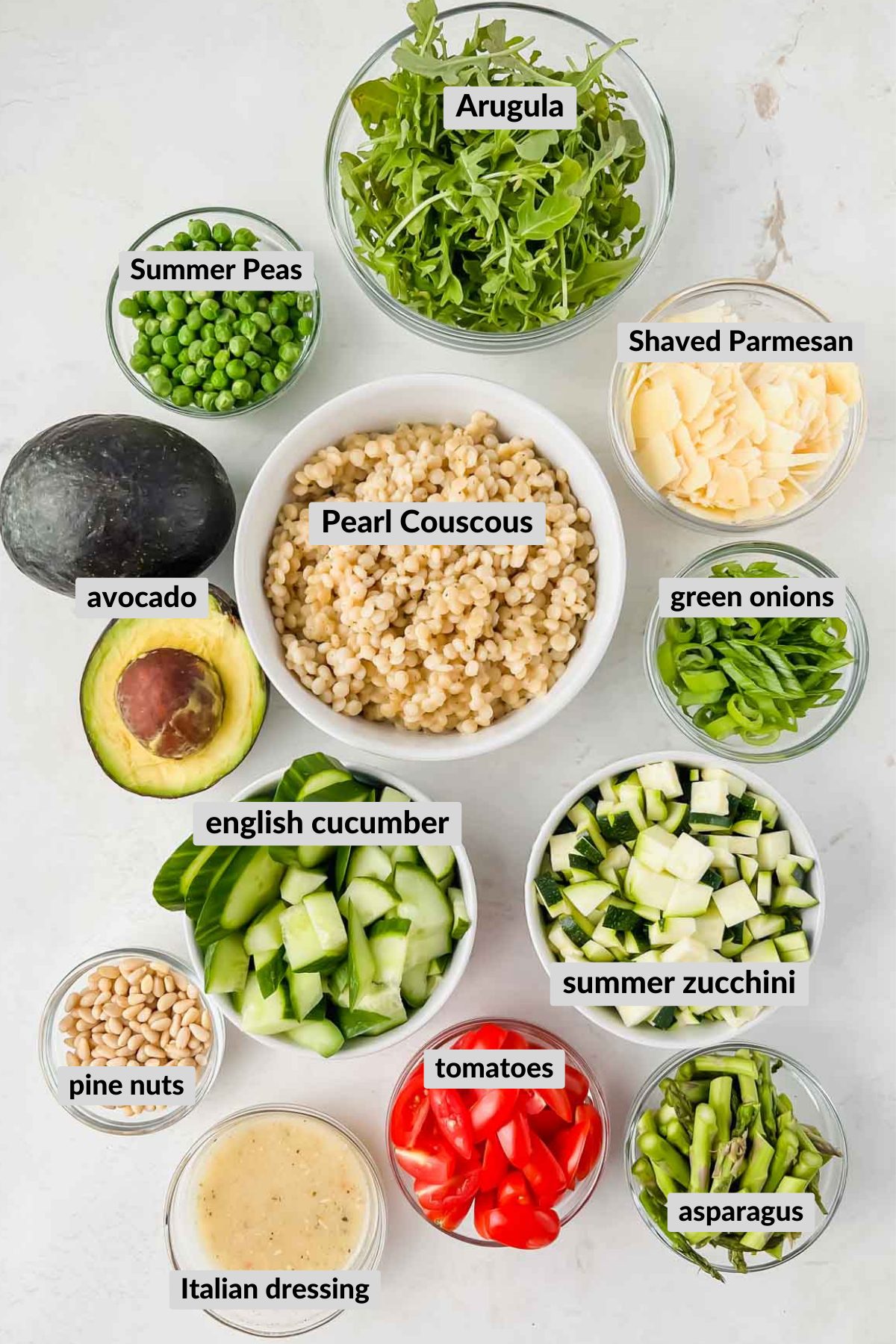labeled ingredients for green summer salad in individual bowls.