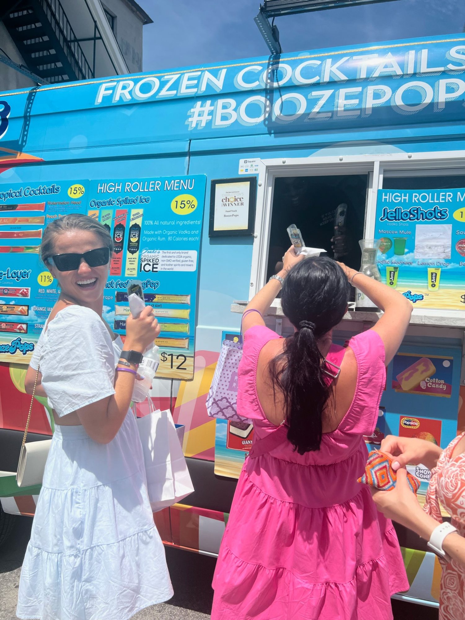 two girls getting booze pops from a ice cream truck. 