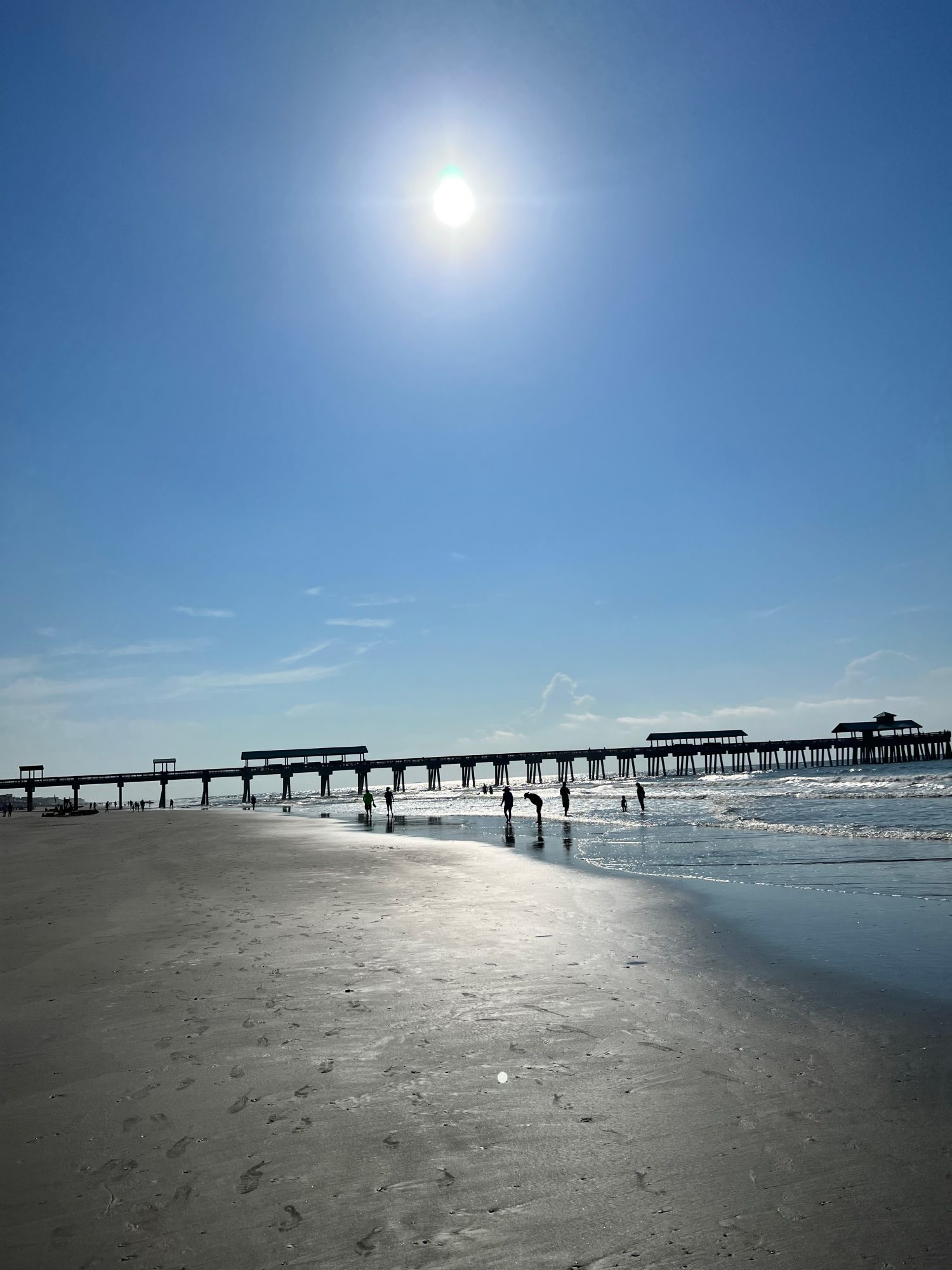 calm morning overlooking the pier and low tide on Folly Beach, South Carolina.