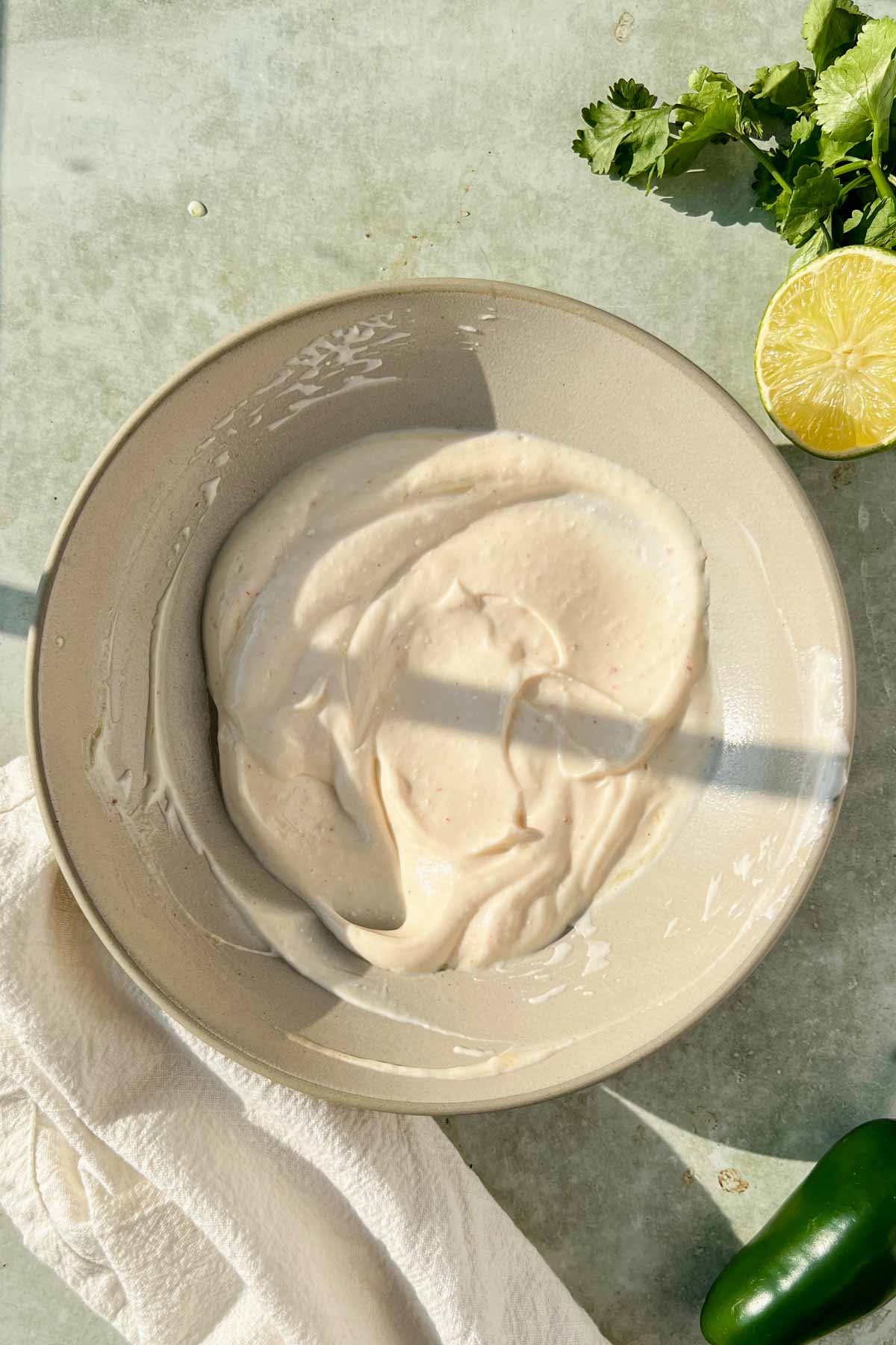 creamy white dressing mixed in a tan bowl.