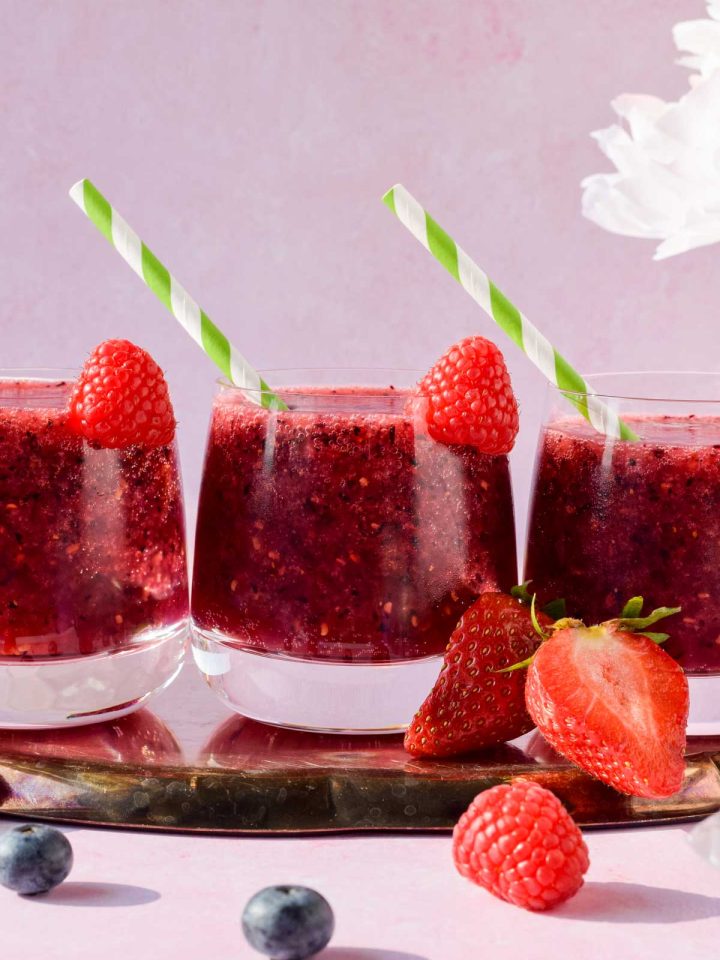 3 glasses of frozen berry prosecco sangria garnished with fresh raspberry.