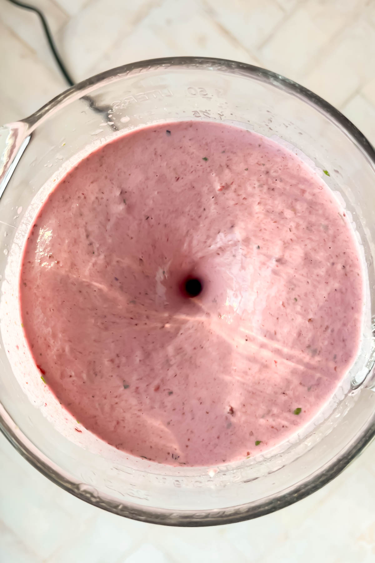 berry smoothie being blended in blender.