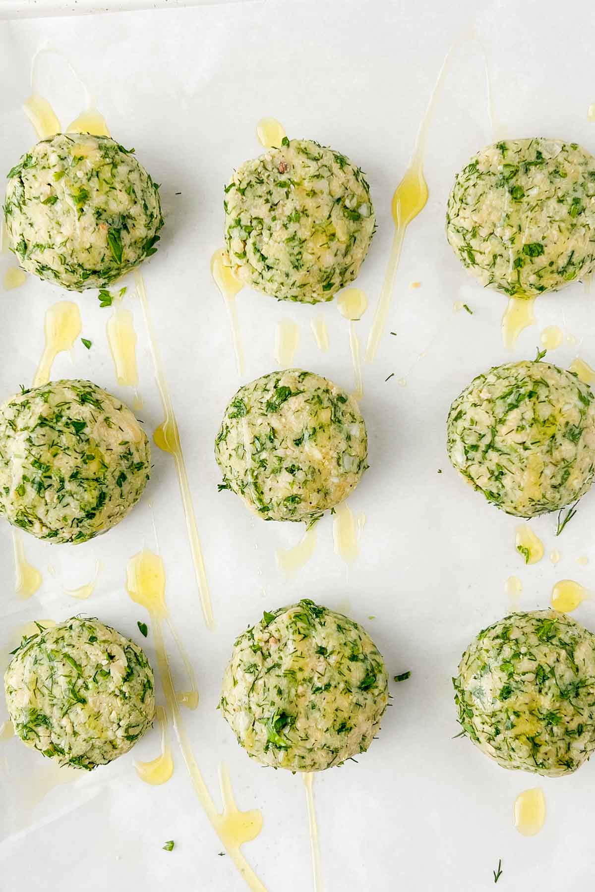 formed falafel balls on parchment lined sheet pan drizzled with olive oil before baking.
