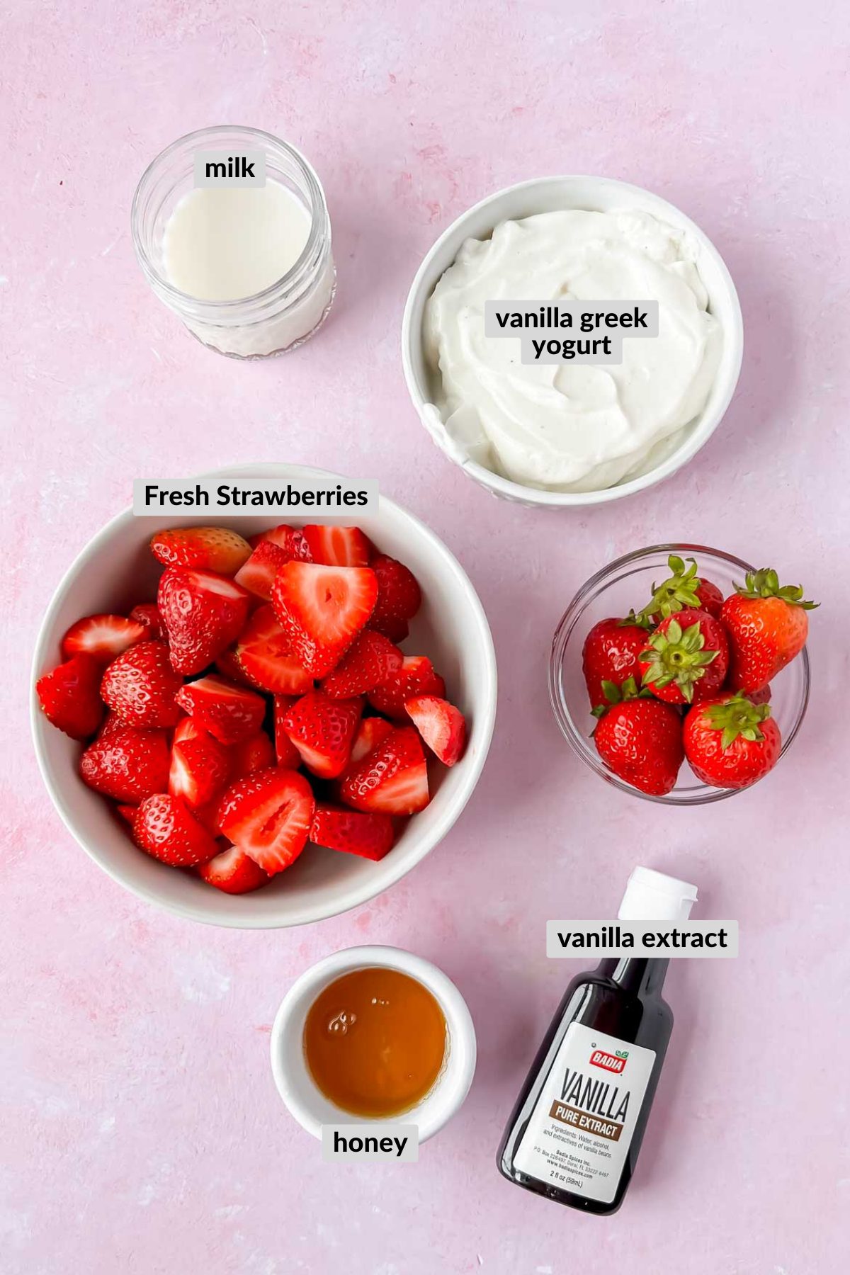 ingredients for frozen yogurt tubes in individual bowls on pink background.