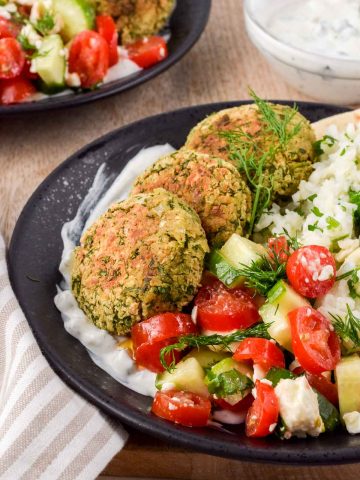 falafel rice bowl garnished with cucumber tomato salad, dill and tzatziki.