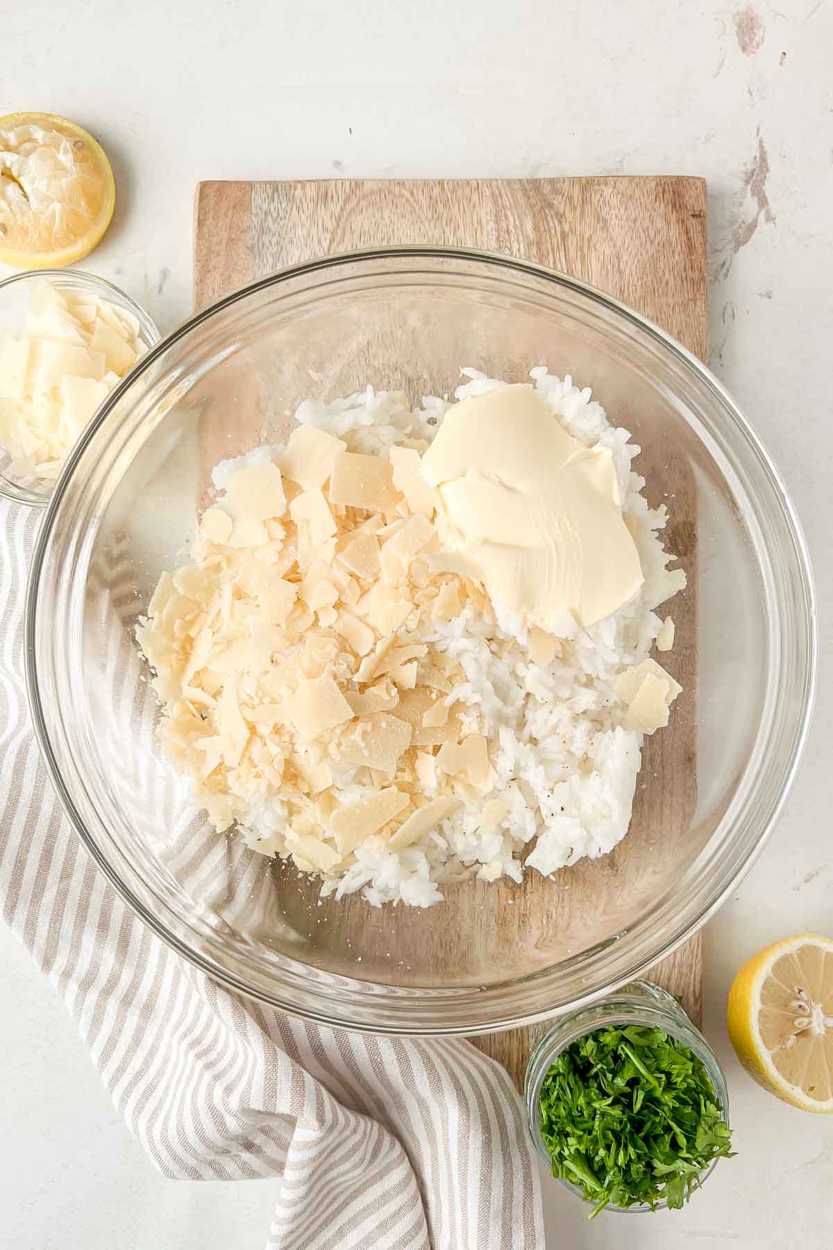cooked jasmine rice, butter and parmesan in glass mixing bowl.