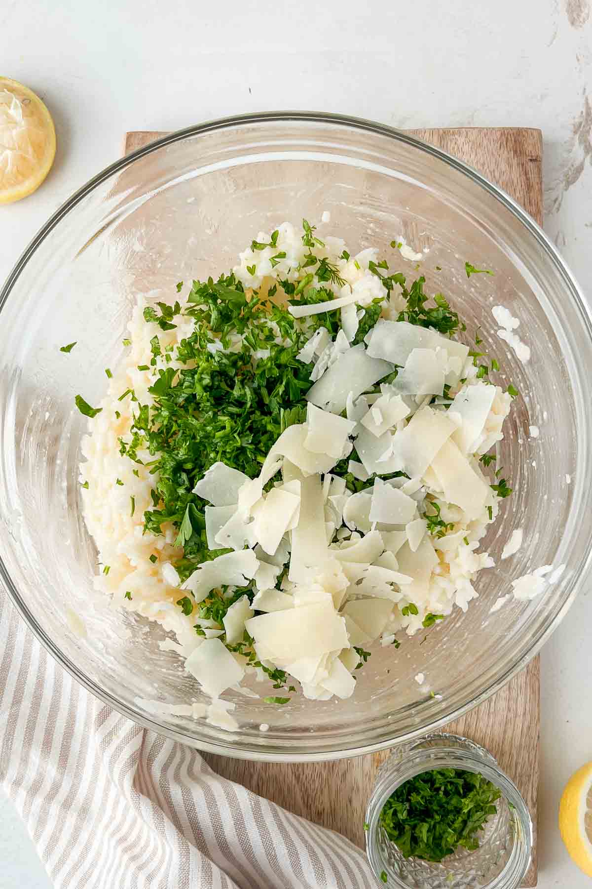 cooked jasmine rice, butter, herbs and parmesan in glass mixing bowl.