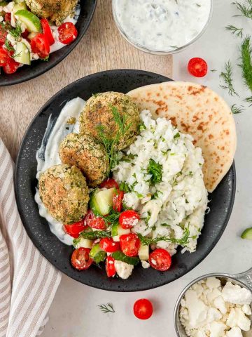 falafel rice bowl garnished with cucumber tomato salad, dill and served with pita.