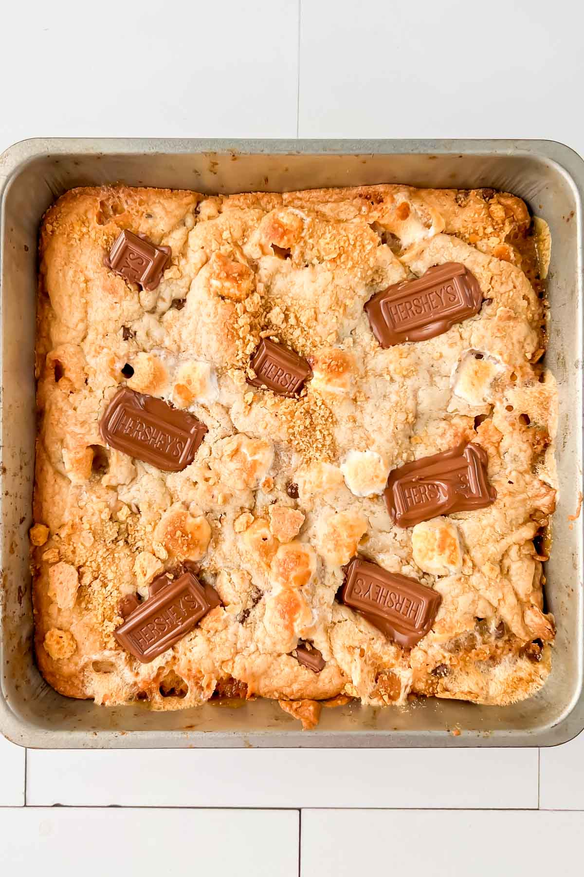 Smores casserole in square pan with hersheys squares on top.