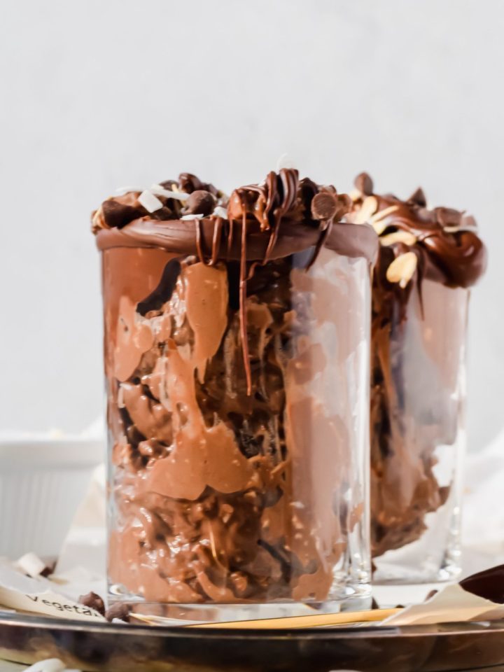 jar of mixed almond joy overnight oats garnished with extra chocolate dripping down side of glass.