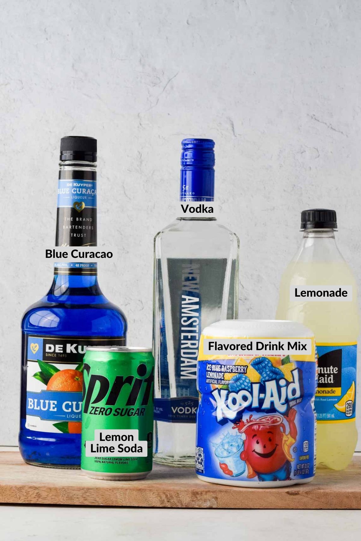 Blue Curacao, Vodka, Lemonade, Kool-Aid, and Sprite on a wood cutting board.