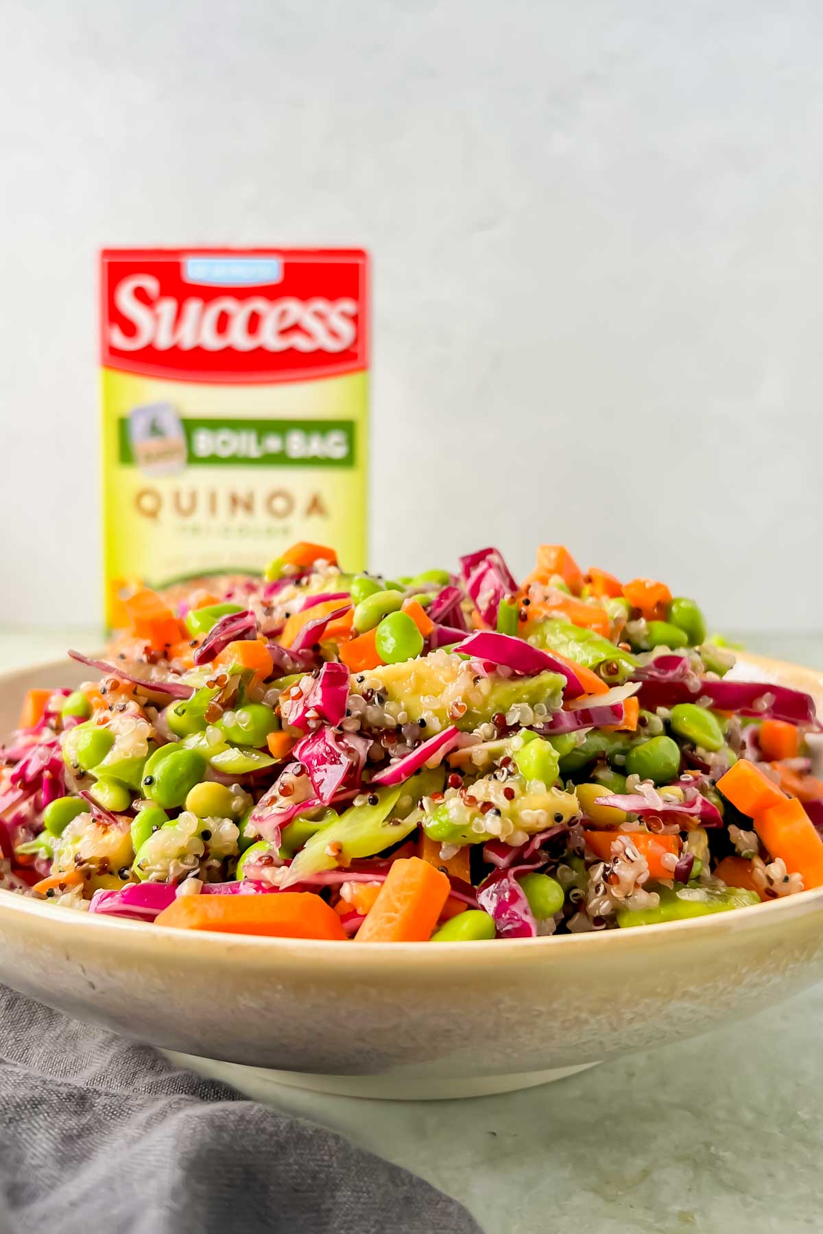 close up view of Quinoa Edamame salad with Success Rice packaging in background.