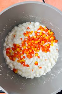 melted mini marshmallows with candy corn added into sauce pot.