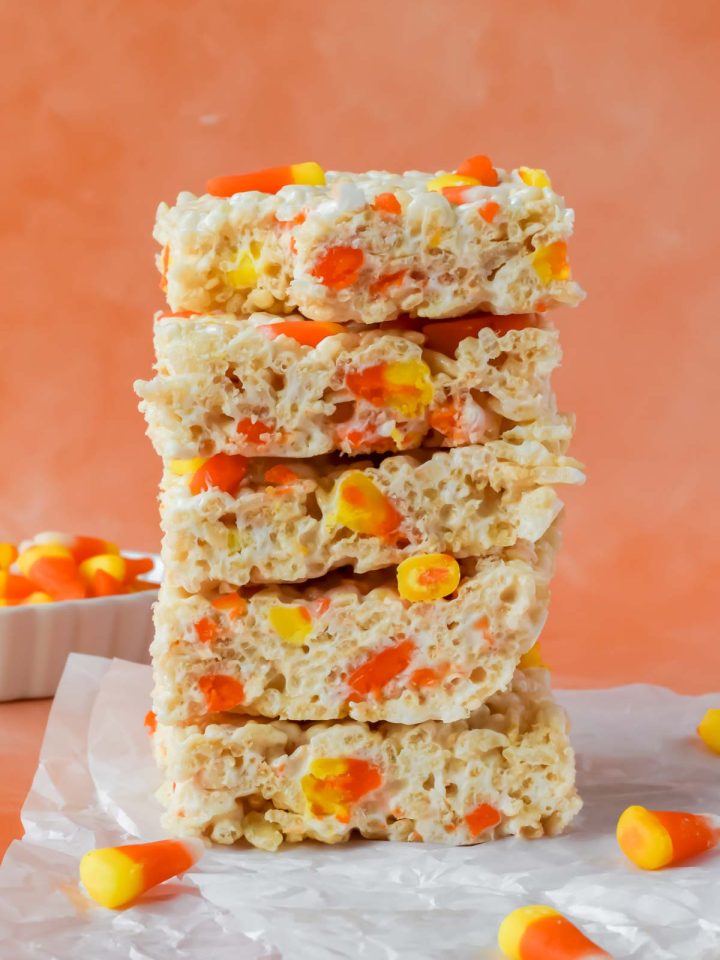 5 stacked candy corn rice krispie treats on parchment paper.