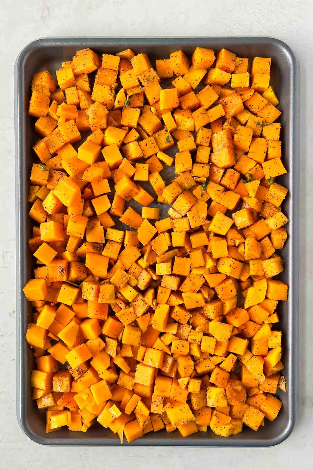 diced and cubed butternut squash on sheet pan ready to be roasted.