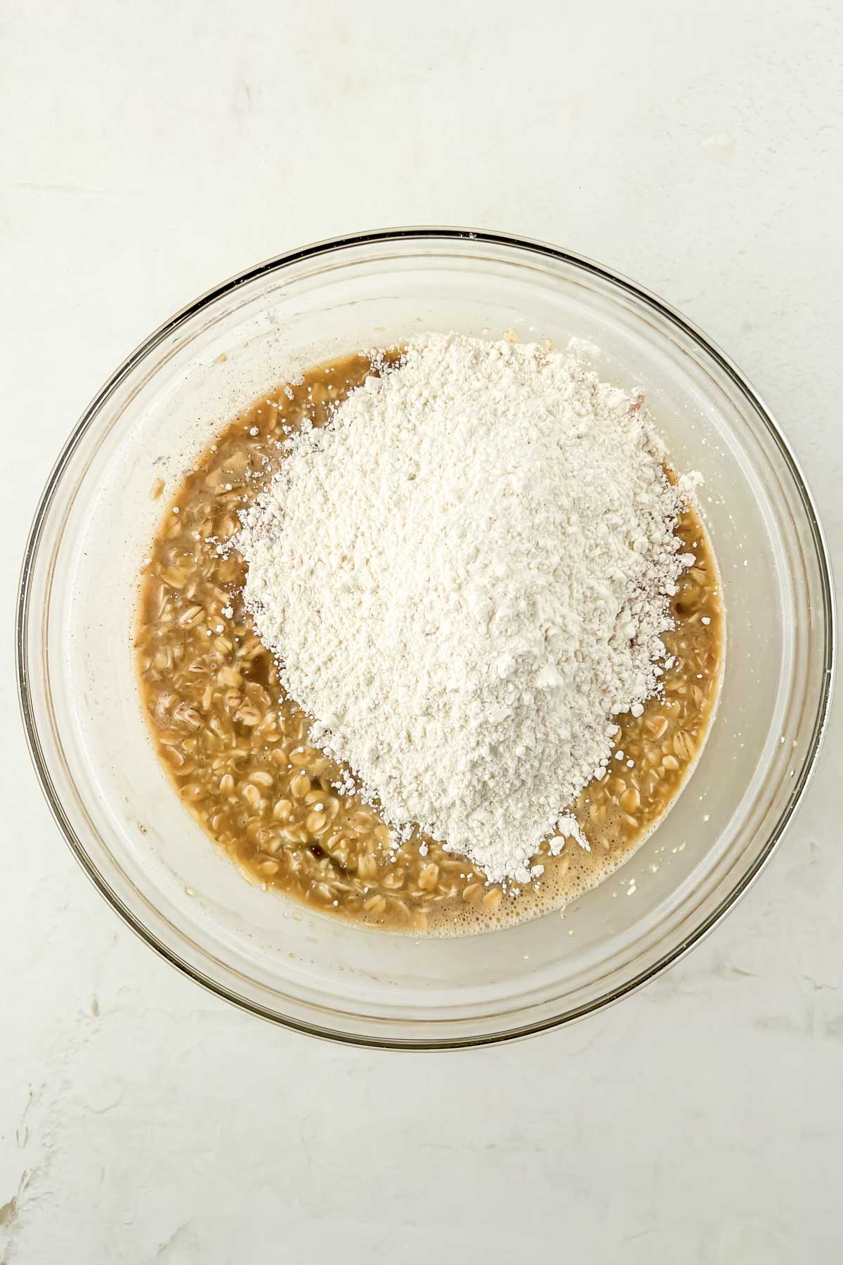 oatmeal raisin muffin batter unmixed in glass mixing bowl.